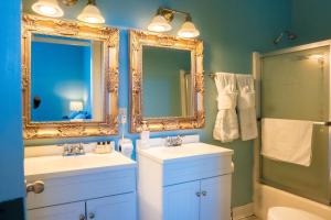 un baño con dos lavabos y dos espejos en Oak Tree Hotel, en Arcadia 274 fotos más
