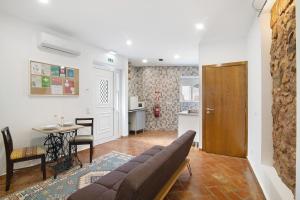uma sala de estar com um sofá e uma mesa em Casa da Vila nº 6 em São Brás de Alportel