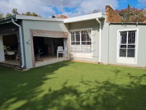 a white house with a lawn in front of it at Streetview Suites in Polokwane