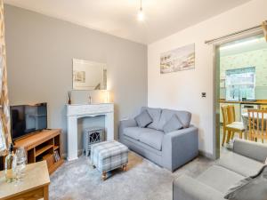 uma sala de estar com um sofá e uma lareira em Horseshoe Cottage em Skegness