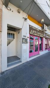 un bâtiment avec une porte rose et violette dans une rue dans l'établissement Center Studio Apartamento en el centro de Trelew, à Trelew