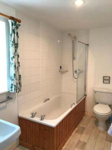 y baño con bañera, aseo y ducha. en Stable Cottage, Ardnadrochet en Lochdon