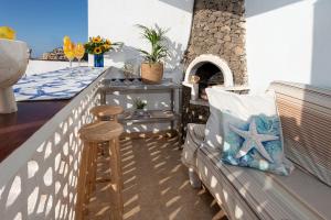 a bench on a balcony with a table and a brick oven at Beachfront two bedrooms house Casa Toral in Majanicho