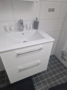 ein Badezimmer mit einem weißen Waschbecken und einem Spiegel in der Unterkunft Fancsali Lak 