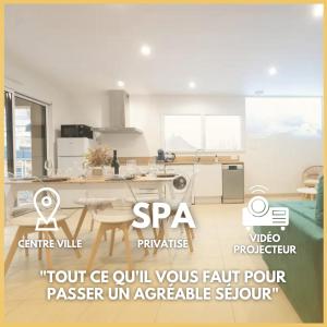 a white kitchen with a table and a counter top at Appart Hôtel La Gacilly-centre ville-SPA-parking in La Gacilly