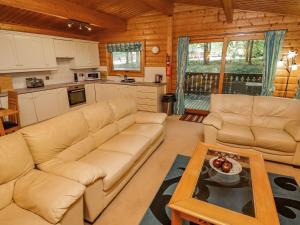 sala de estar con 2 sofás y cocina en Bamboo Retreat, en Legbourne