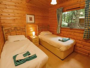 1 dormitorio con 2 camas en una cabaña de madera en Bamboo Retreat, en Legbourne