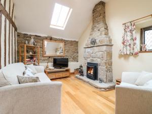 a living room with a stone fireplace and a tv at 33 Main Road in Alfreton