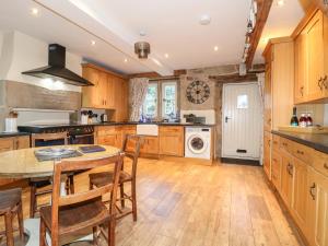 a kitchen with wooden cabinets and a table at 33 Main Road in Alfreton