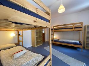 two bunk beds in a room with blue floors at Da Silva Surfcamp 4 Bettzimmer mit Frühstück in Lourinhã