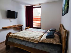 ein kleines Schlafzimmer mit einem Bett und einem Fenster in der Unterkunft Chalety Bystrá in Bystrá