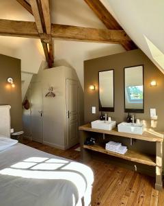 a bedroom with two sinks and two mirrors at Le Château de Saint-Angel, Le Manoir du Rigouneix, 5 minutes A89, nature, calme, sauna, CLIMATISATION in Saint-Angel
