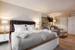 a bedroom with a large bed and a couch at Hotel Zweite Heimat in Sankt Peter-Ording