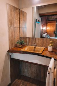 uma casa de banho com um lavatório de madeira e um espelho em La Saucina - Cabaña Rústica Chic em Tunuyán