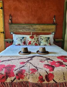 um quarto com uma cama com dois chapéus em La Saucina - Cabaña Rústica Chic em Tunuyán