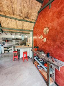 uma cozinha com uma mesa e dois bancos vermelhos em La Saucina - Cabaña Rústica Chic em Tunuyán