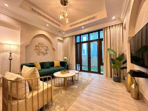 un soggiorno con divano verde e tavolo di Durrani Homes - Heaven On Earth- Burj Khalifa Fireworks a Dubai