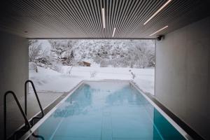 a swimming pool in a house with snow on the ground at Haus Jausern in Saalbach Hinterglemm