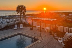 a sunset over a swimming pool and the ocean at Veranda 101 in Fort Walton Beach