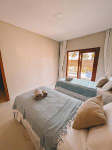twee bedden in een kamer met een raam bij Linda casa de praia com Piscina privativa in Prea