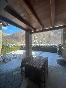 a patio with a wooden table and chairs on a patio at Le Petit Chalet Limone in Limone Piemonte