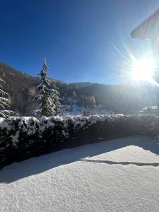 a snow covered fence with the sun in the background at Le Petit Chalet Limone in Limone Piemonte