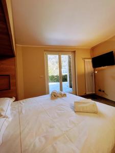 sypialnia z dużym łóżkiem z dwoma ręcznikami w obiekcie Le Petit Chalet Limone w mieście Limone Piemonte