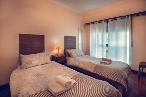 1 Schlafzimmer mit 2 Betten und einem Fenster in der Unterkunft Casa de Rana - Beach & City in Rana