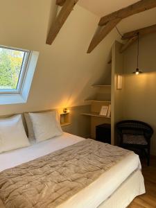 een slaapkamer met een groot bed en een raam bij Le Manoir du Rigouneix au coeur de la nature, calme-sauna-dîner maison in Saint-Angel