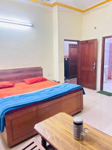 1 dormitorio con 1 cama grande y 1 mesa en Sunrise hotel, en Jalandhar