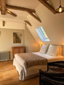 een slaapkamer met een groot bed op zolder bij Le Manoir du Rigouneix au coeur de la nature, calme-sauna-dîner maison in Saint-Angel