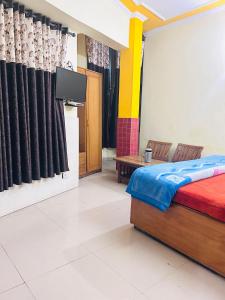 ein Schlafzimmer mit einem Bett und einem TV. in der Unterkunft Sunrise hotel in Jalandhar