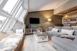 a living room with a couch and a tv at Hotel Zweite Heimat in Sankt Peter-Ording