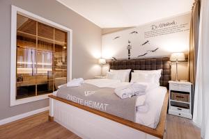 ein Schlafzimmer mit einem großen Bett und einem Fenster in der Unterkunft Hotel Zweite Heimat in Sankt Peter-Ording