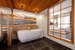 a bath tub in a bathroom with a window at Hotel Zweite Heimat in Sankt Peter-Ording +37 photos