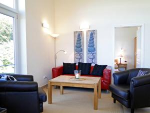 a living room with a red couch and a table at Leuchtturm in Bohnert