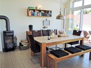 a dining room with a table and a wood stove at Leuchtturm in Bohnert