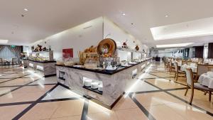 a restaurant with a buffet line with tables and chairs at Mias Al Madina Hotel in Al Madinah