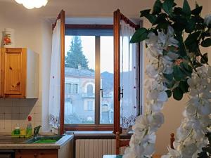 a kitchen window with a view of a building at Grazioso bilocale Merlino, luminoso con vista Santuario, wifi in Giaveno