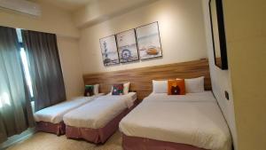 una habitación de hotel con 2 camas en una habitación en Rainbow Hotel en Magong