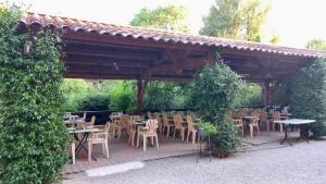 a group of tables and chairs under a pavilion at Hôtel Sous l'Olivier in Buis-les-Baronnies