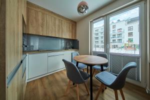 a kitchen with a table and chairs and a window at Mountain Gem Zakopane in Zakopane