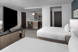 兰辛Hyatt House Lansing-University Area的一间配有床和平板电视的酒店房间