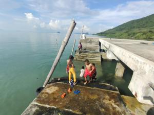 a group of people standing on a dock in the water at บ้านปู in Ko Yao Noi