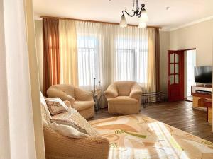 a living room with two chairs and a television at Hotel Europa in Truskavets