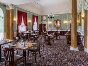 a dining room with tables and chairs at Hitchin Priory Hotel in Hitchin