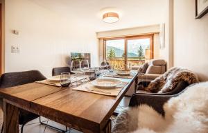 een eetkamer met een houten tafel en stoelen bij Quiet ski and golf apartment in Verbier