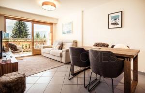 een woonkamer met een tafel en een bank bij Quiet ski and golf apartment in Verbier