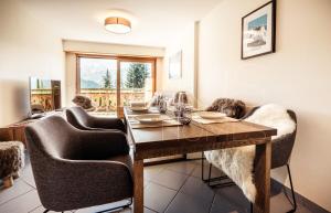 een eetkamer met een tafel en stoelen bij Quiet ski and golf apartment in Verbier