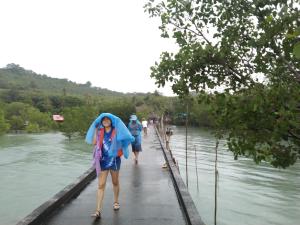 a woman walking on a bridge with an umbrella at บ้านปู in Ko Yao Noi